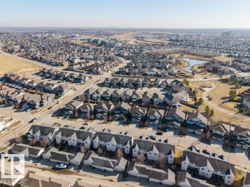 Aerial perspective of a suburban neighborhood featuring residential homes, townhouses, and a community pond - Edmonton, AB - Outdoor With View