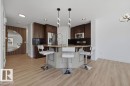 Kitchen with wood-finish flooring, dark wood cabinetry, and stainless steel appliances - Edmonton, AB  - Indoor Photo Showing Kitchen With Stainless Steel Kitchen With Upgraded Kitchen 