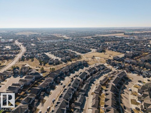 Expansive aerial view showcasing a developed residential neighborhood with numerous detached homes, paved streets, and a clear sky above - Edmonton, AB - Outdoor With View