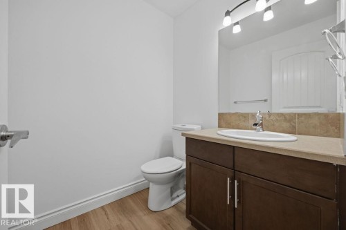 Vanity with an oval undermount sink, beige countertop, and tile backsplash - Edmonton, AB - Indoor Photo Showing Bathroom