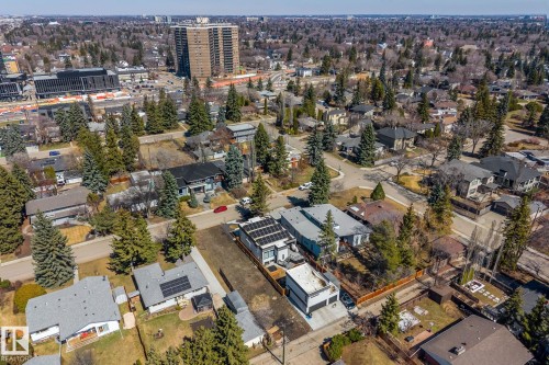 Contemporary residences with solar panel installations, set within a residential area featuring mature trees and established streetscapes - 14013 101 Avenue, Edmonton, AB 