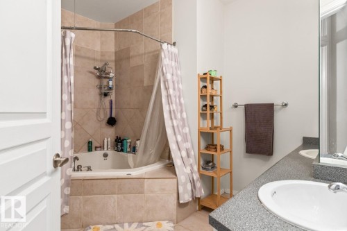 Corner soaking tub with tile surround and wall-mounted showerhead - 109 10728 82 Avenue, Edmonton, AB - Indoor Photo Showing Bathroom