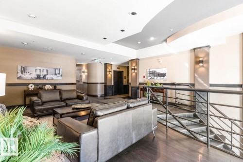 Spacious common area featuring dark wood-finish flooring, recessed lighting, and wall-mounted sconces - 109 10728 82 Avenue, Edmonton, AB - Indoor
