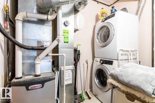 Dedicated utility area featuring a Lennox furnace and stacked laundry appliances - 109 10728 82 Avenue, Edmonton, AB - Indoor Photo Showing Laundry Room