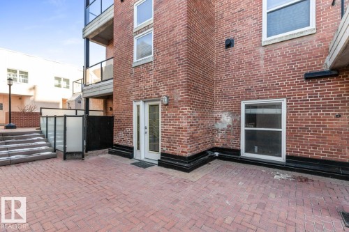 Red brick exterior with a ground-level patio featuring brick pavers - 109 10728 82 Avenue, Edmonton, AB - Outdoor With Exterior