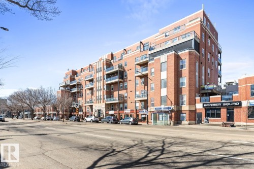 Multi-story brick building featuring multiple private balconies, ground-level retail spaces, and a prominent street-facing facade - 109 10728 82 Avenue, Edmonton, AB - Outdoor