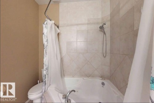 Soaking tub with integrated jets and chrome fixtures - 109 10728 82 Avenue, Edmonton, AB - Indoor Photo Showing Bathroom