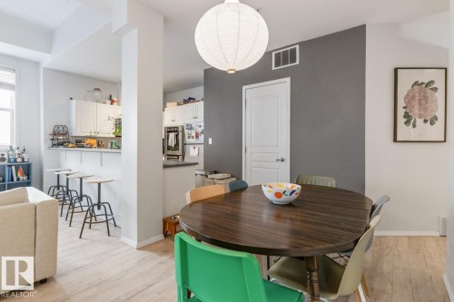 Dining area featuring a dark wood-finish dining table and a white paper lantern pendant light - 109 10728 82 Avenue, Edmonton, AB - Indoor Photo Showing Dining Room