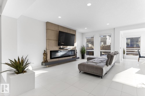 Living space featuring light-colored tile flooring, white walls, and recessed lighting - 793 Windermere Wynd, Edmonton, AB - Indoor Photo Showing Living Room With Fireplace