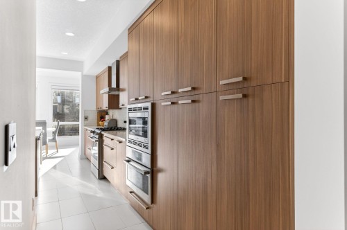 Kitchen featuring wood-finish cabinetry, stainless steel appliances, and tile flooring - 793 Windermere Wynd, Edmonton, AB - Indoor Photo Showing Kitchen