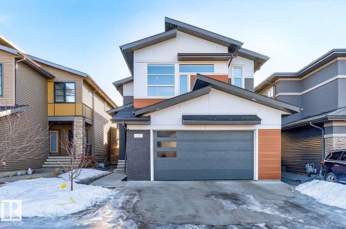 Contemporary architectural design featuring a multi-gabled roofline and a mix of white siding, dark brick, and wood-finish accents - 793 Windermere Wynd, Edmonton, AB - Outdoor