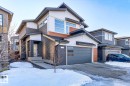 Contemporary two-story residence featuring a dark gray garage door with horizontal windows, a concrete driveway, and a covered entry - 793 Windermere Wynd, Edmonton, AB  - Outdoor 