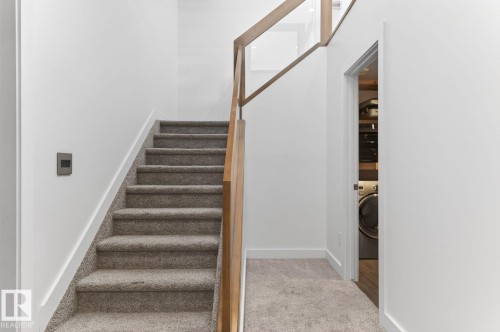Carpeted staircase with contemporary wood and glass railing - 793 Windermere Wynd, Edmonton, AB - Indoor Photo Showing Other Room