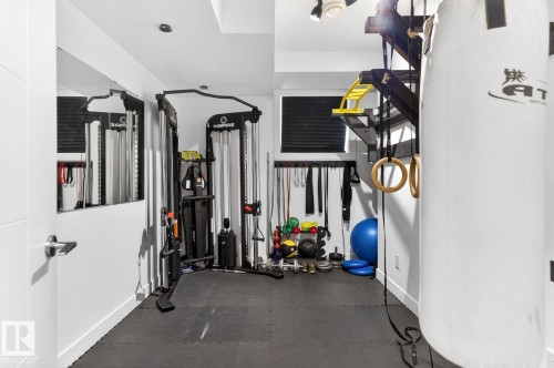 Dedicated fitness area featuring rubber flooring, a built-in heavy bag mount, and recessed lighting - 793 Windermere Wynd, Edmonton, AB - Indoor Photo Showing Gym Room