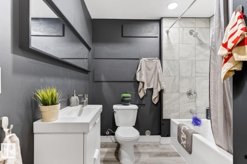 Bathroom featuring a white vanity with integrated sink, chrome faucet, and rectangular mirror - 793 Windermere Wynd, Edmonton, AB - Indoor Photo Showing Bathroom