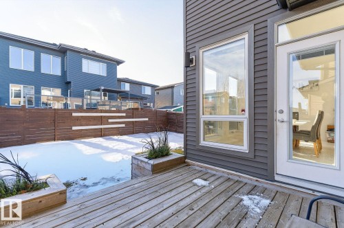 Outdoor wooden deck with planter boxes, offering a private backyard area with a horizontal plank fence - 793 Windermere Wynd, Edmonton, AB - Outdoor With Deck Patio Veranda