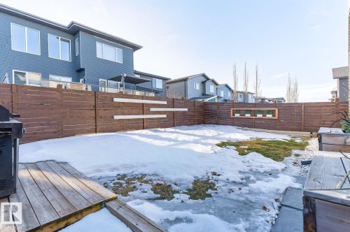 Private backyard with wood fencing and a ground-level deck platform - 793 Windermere Wynd, Edmonton, AB - Outdoor