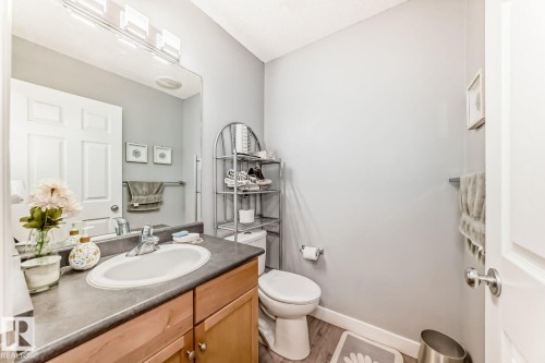Bathroom featuring a wood-finish vanity with a laminate countertop and integrated sink - 715 Hudson Place, Edmonton, AB - Indoor Photo Showing Bathroom