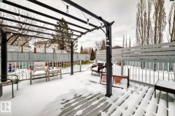 Deck featuring a dark metal pergola with string lighting, light wood-finish decking, and a perimeter railing - 