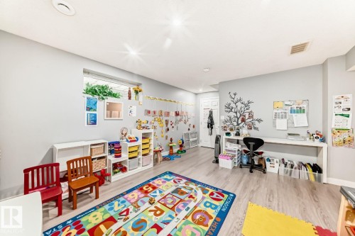 Versatile lower level space featuring light gray walls, wood-finish flooring, recessed lighting, and a built-in desk area - 715 Hudson Place, Edmonton, AB - Indoor Photo Showing Other Room