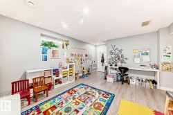 Versatile lower level space featuring light gray walls, wood-finish flooring, recessed lighting, and a built-in desk area - 