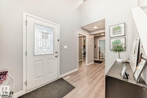 Entryway featuring a decorative glass panel door, light wood-finish flooring, and a mirrored closet door - 715 Hudson Place, Edmonton, AB - Indoor Photo Showing Other Room