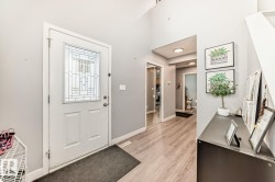 Entryway featuring a decorative glass panel door, light wood-finish flooring, and a mirrored closet door - 
