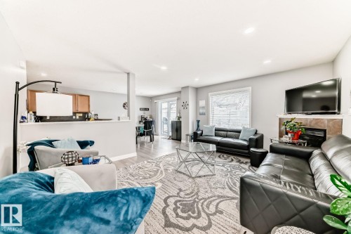 Open-concept living area with wood-finish flooring, recessed lighting, and a window with horizontal blinds - 715 Hudson Place, Edmonton, AB - Indoor Photo Showing Living Room