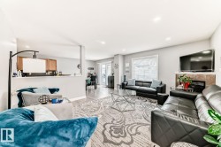 Open-concept living area with wood-finish flooring, recessed lighting, and a window with horizontal blinds - 