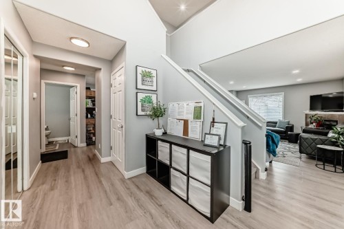 Bright entry hall with wood-finish flooring, white baseboards, and light gray walls - 715 Hudson Place, Edmonton, AB - Indoor Photo Showing Other Room