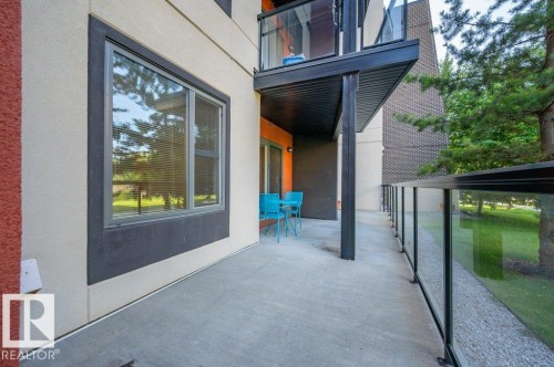 Spacious concrete patio with modern glass and metal railings - 140 308 Ambleside Link Link Sw, Edmonton, AB - Outdoor With Exterior