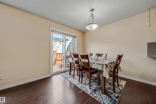 Dining area featuring dark wood-finish flooring, light cream walls, and a contemporary pendant light fixture - 2314 22 Avenue, Edmonton, AB - Indoor Photo Showing Dining Room
