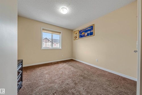 Carpeted interior room with neutral-toned walls, white trim, and a flush-mount ceiling light fixture - 2314 22 Avenue, Edmonton, AB - Indoor Photo Showing Other Room