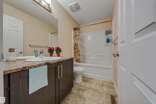 Bathroom featuring a single vanity with dark wood-finish cabinetry, a white oval undermount sink, and a laminate countertop - 2314 22 Avenue, Edmonton, AB - Indoor Photo Showing Bathroom
