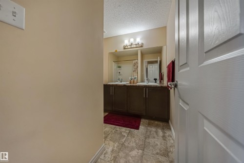 Bathroom featuring a dual vanity with dark wood-finish cabinetry, granite-style countertops, and undermount sinks - 2314 22 Avenue, Edmonton, AB - Indoor Photo Showing Other Room