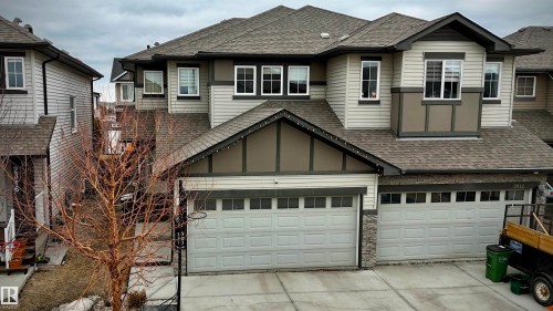 Two-story residence featuring a gray shingle roof, light-colored siding, and stacked stone accents - 2314 22 Avenue, Edmonton, AB - Outdoor With Facade