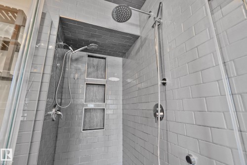 Glass-enclosed shower featuring subway tile, dual shower heads, and built-in recessed shelving - 13635 108 Avenue, Edmonton, AB - Indoor Photo Showing Bathroom