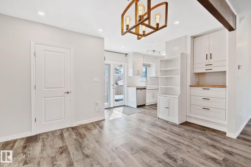 Bright interior featuring wood-finish flooring, recessed lighting, and a modern chandelier - 13635 108 Avenue, Edmonton, AB - Indoor Photo Showing Other Room
