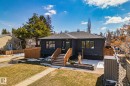 Modern bungalow featuring a dark exterior finish, a prominent wooden staircase, and a gray shingled roof - 13635 108 Avenue, Edmonton, AB  - Outdoor With Deck Patio Veranda 