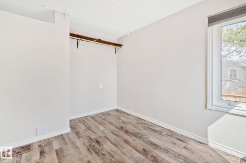 Neutral wall color with wood-finish flooring - 13635 108 Avenue, Edmonton, AB - Indoor Photo Showing Other Room