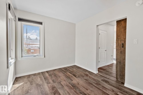 Neutral wall paint with durable wood-finish flooring - 13635 108 Avenue, Edmonton, AB - Indoor Photo Showing Other Room