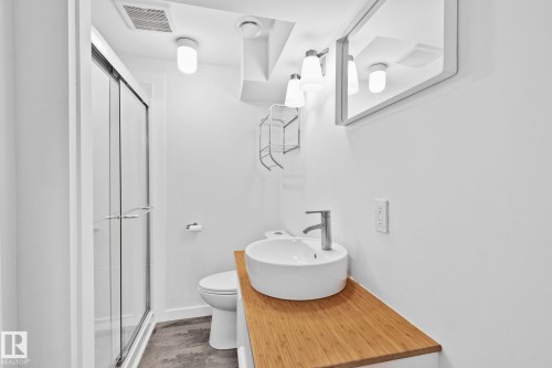 Contemporary bathroom featuring a glass-enclosed shower, round vessel sink, and wood-finish vanity - 13635 108 Avenue, Edmonton, AB - Indoor Photo Showing Bathroom