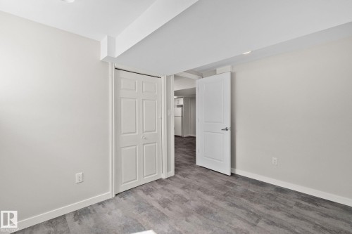 Neutral-toned walls complement the wood-finish flooring - 13635 108 Avenue, Edmonton, AB - Indoor Photo Showing Other Room
