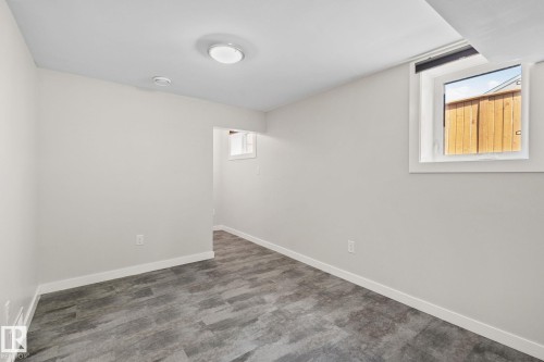 Spacious room featuring light gray walls, wood-finish flooring, white trim, and a flush-mount ceiling light - 13635 108 Avenue, Edmonton, AB - Indoor Photo Showing Other Room