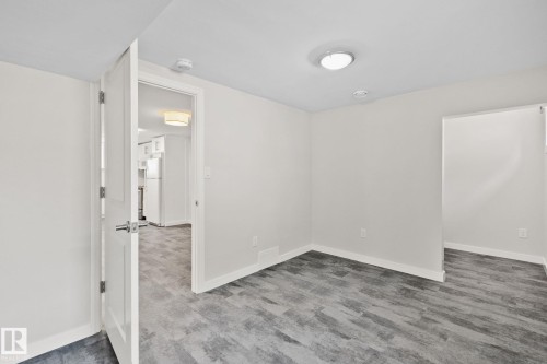Interior room featuring wood-finish flooring, white walls, and bright overhead lighting - 13635 108 Avenue, Edmonton, AB - Indoor Photo Showing Other Room