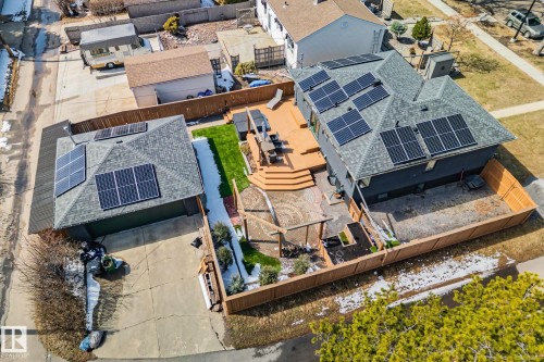 Main residence with dark gray siding and a gray shingle roof featuring multiple solar panel arrays - 13635 108 Avenue, Edmonton, AB - Outdoor