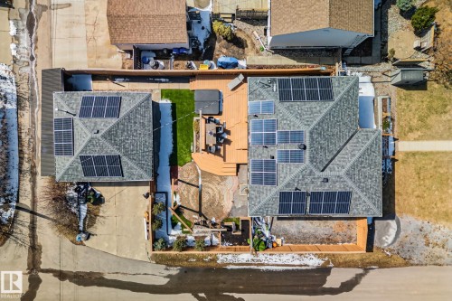 Aerial perspective of two properties featuring multiple solar panel installations on shingled roofs - 13635 108 Avenue, Edmonton, AB - 