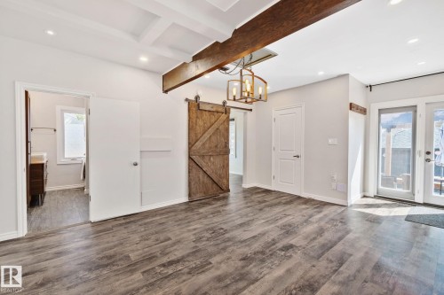 Spacious interior featuring wood-finish flooring, a coffered ceiling, and exposed wood beams - 13635 108 Avenue, Edmonton, AB - Indoor Photo Showing Other Room