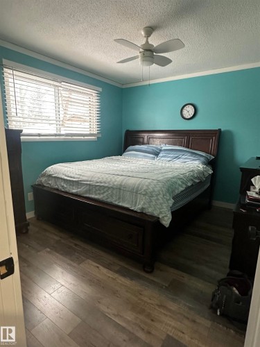 This room features wood-style flooring, a window with blinds, and a ceiling fan - 5420 40 Avenue, Wetaskiwin, AB - Indoor Photo Showing Bedroom