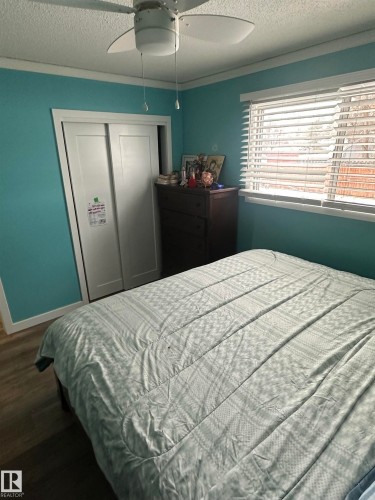 This room features wood-style flooring, a ceiling fan, and a window with blinds - 5420 40 Avenue, Wetaskiwin, AB - Indoor Photo Showing Bedroom